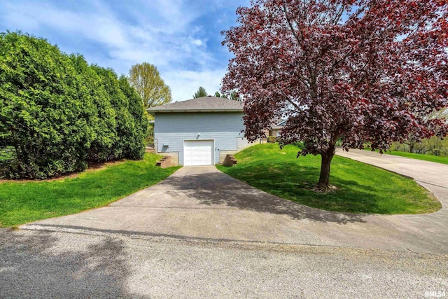 view of front of home with driveway, a front lawn, and a garage