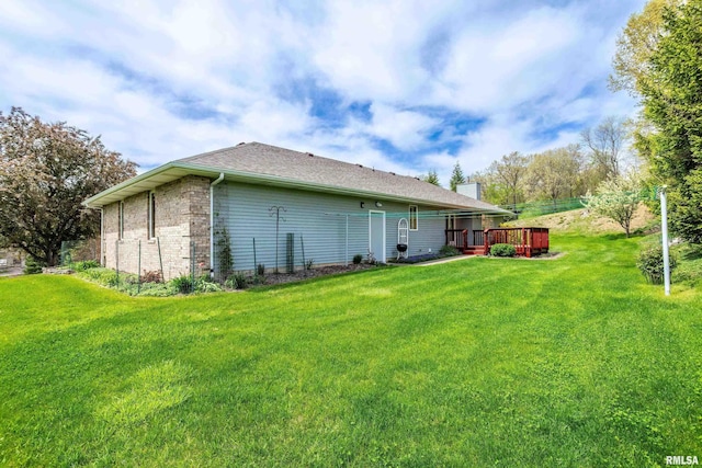 rear view of property with a lawn, a wooden deck, and a chimney