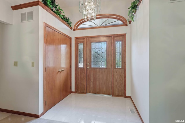foyer with baseboards, a chandelier, and visible vents