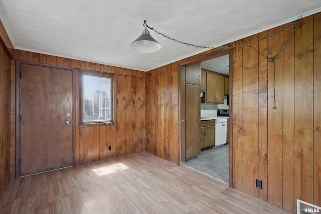 interior space featuring visible vents, light wood-style flooring, crown molding, and wooden walls