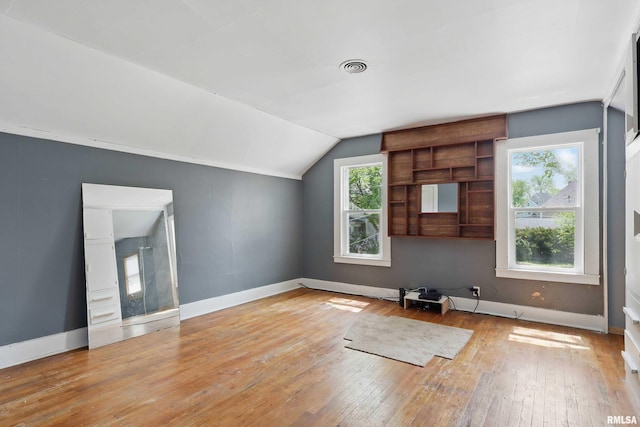 bonus room featuring baseboards, vaulted ceiling, and hardwood / wood-style flooring