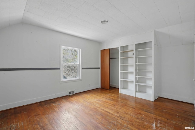 unfurnished bedroom featuring baseboards, visible vents, and hardwood / wood-style floors