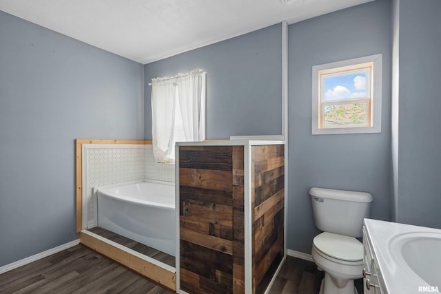 full bath featuring a garden tub, wood finished floors, a healthy amount of sunlight, and toilet