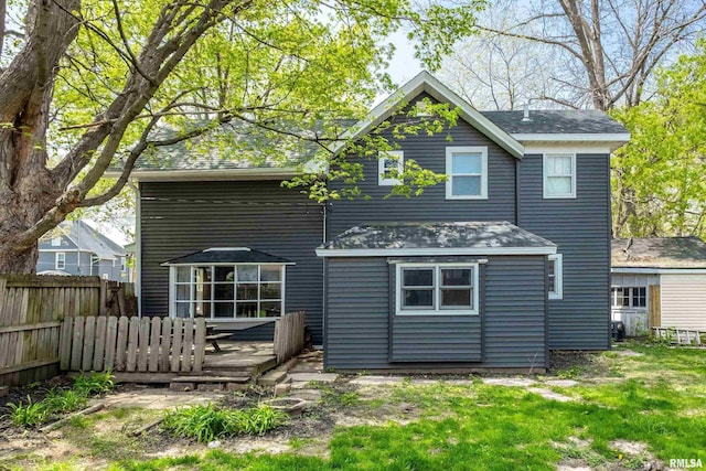 rear view of house featuring a yard, a deck, and fence