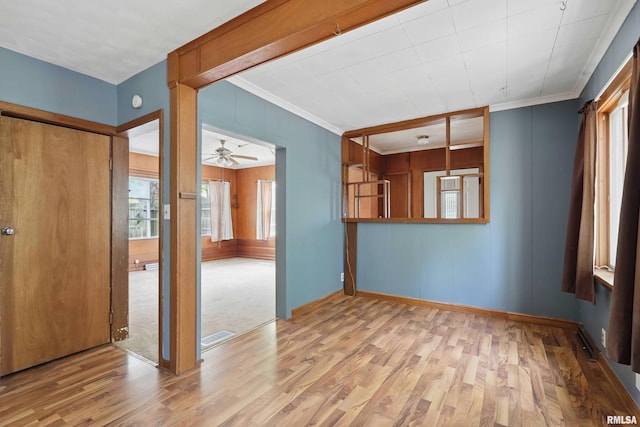 unfurnished room featuring baseboards, ornamental molding, a ceiling fan, and wood finished floors
