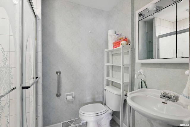 bathroom with toilet, baseboards, visible vents, and a sink