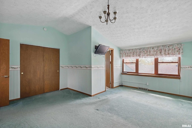interior space featuring carpet floors, a notable chandelier, a textured ceiling, and visible vents