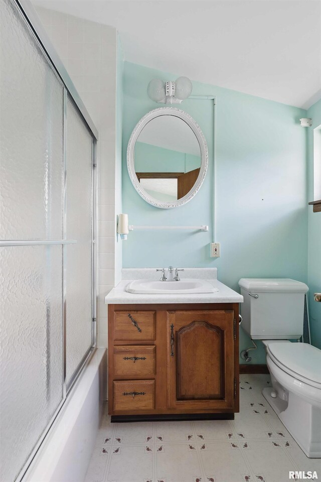 bathroom with vanity, toilet, and shower / bath combination with glass door
