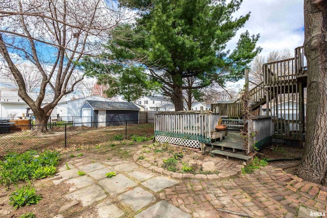 view of yard with a wooden deck, a fenced backyard, a patio area, and stairs