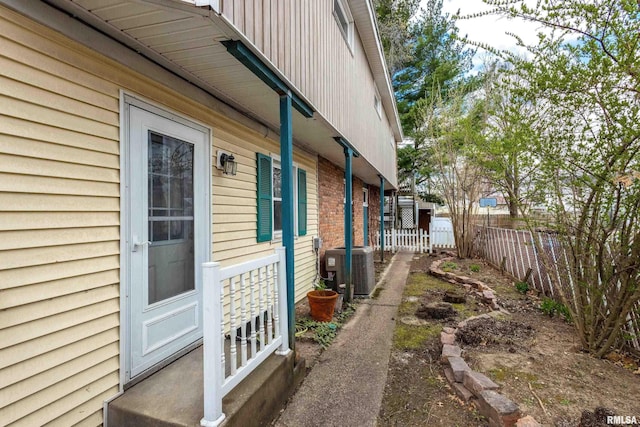 view of home's exterior with central air condition unit and fence