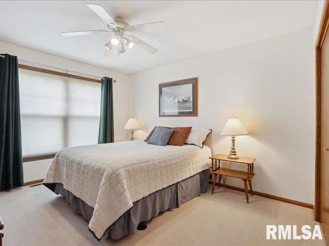 bedroom with baseboards, light carpet, and a ceiling fan
