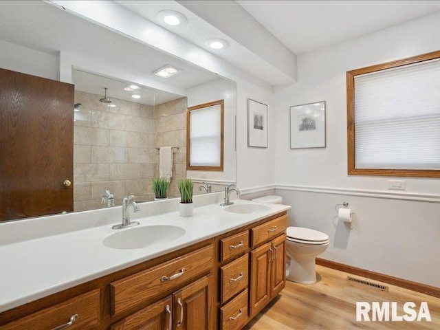 full bath with double vanity, toilet, visible vents, and a sink
