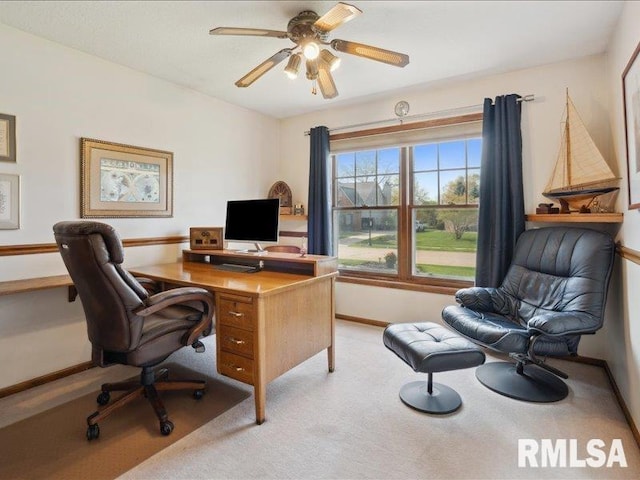 carpeted home office with ceiling fan and baseboards