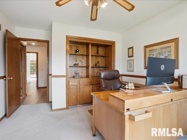 office area featuring ceiling fan, light colored carpet, and baseboards
