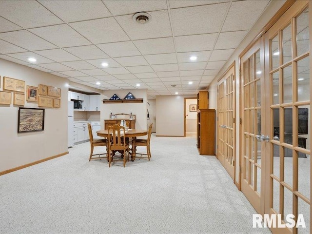 dining room featuring light carpet, baseboards, a drop ceiling, recessed lighting, and french doors