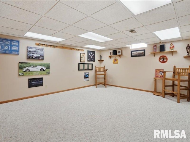 finished below grade area featuring visible vents, baseboards, carpet, and a drop ceiling