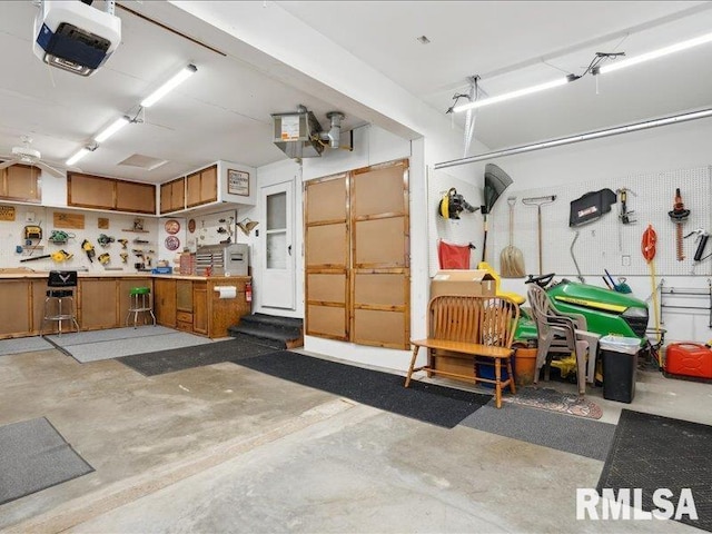 garage with a workshop area and a garage door opener