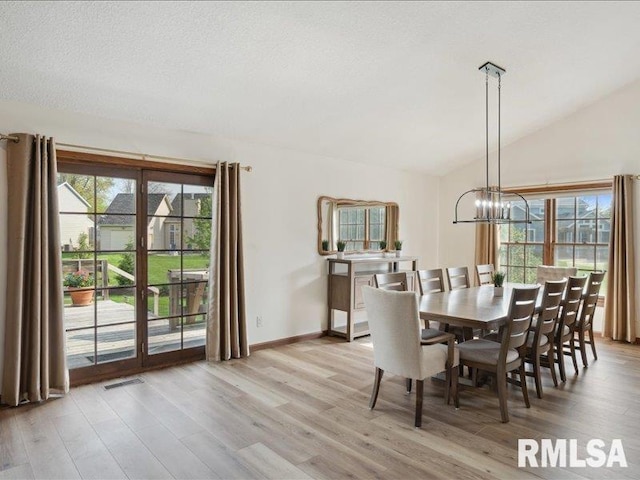 dining area featuring an inviting chandelier, light wood-style flooring, plenty of natural light, and visible vents