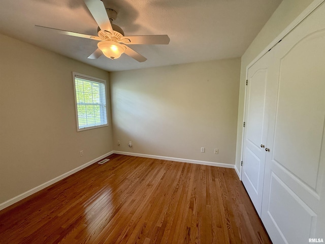 106 Jeremy Dr, Carterville, IL 62918 - unfurnished bedroom with a closet, baseboards, a ceiling fan, and wood finished floors