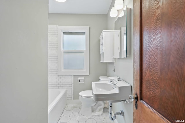 full bathroom featuring baseboards, a sink, tile patterned floors, and toilet