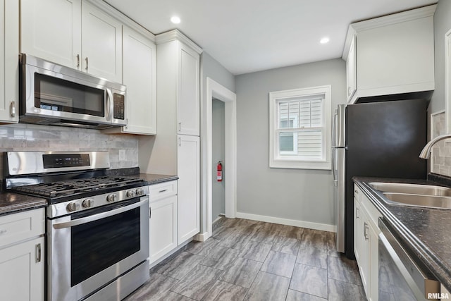 kitchen featuring a sink, white cabinets, tasteful backsplash, and stainless steel appliances