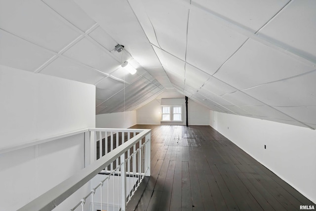 additional living space with vaulted ceiling and dark wood-type flooring