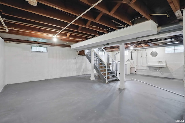 below grade area featuring stairs, washer / clothes dryer, and a wealth of natural light