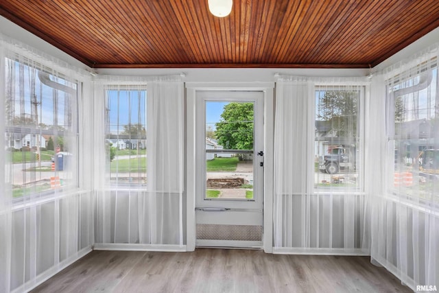 doorway with baseboards, wood ceiling, and wood finished floors