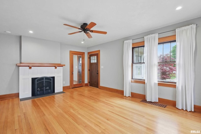 unfurnished living room featuring baseboards, ceiling fan, wood finished floors, and visible vents