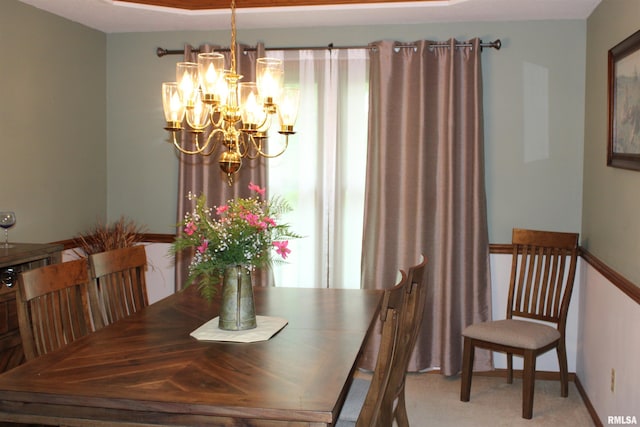 dining space with baseboards, light carpet, and a notable chandelier