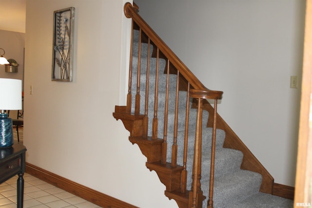 staircase featuring baseboards and tile patterned flooring