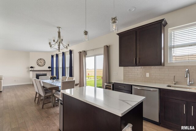 1824 S 5th St, Eldridge, IA 52748 - kitchen with a center island, stainless steel dishwasher, dark brown cabinets, a sink, and open floor plan