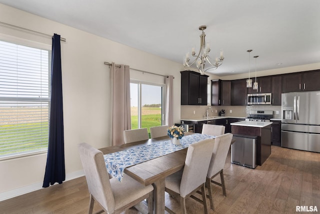 1824 S 5th St, Eldridge, IA 52748 - dining room featuring baseboards, light wood finished floors, and a chandelier