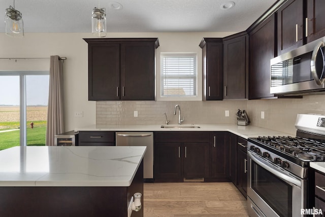 1824 S 5th St, Eldridge, IA 52748 - kitchen featuring appliances with stainless steel finishes, a healthy amount of sunlight, a sink, and light wood-style flooring