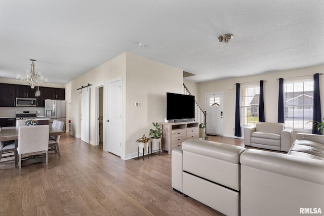 1824 S 5th St, Eldridge, IA 52748 - living room featuring baseboards, a notable chandelier, and wood finished floors