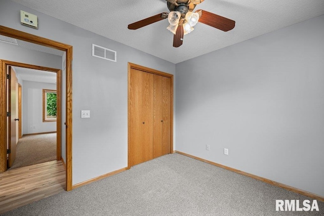 unfurnished bedroom with carpet floors, baseboards, visible vents, and a closet