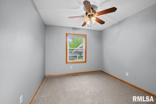 carpeted empty room with a ceiling fan, baseboards, and visible vents