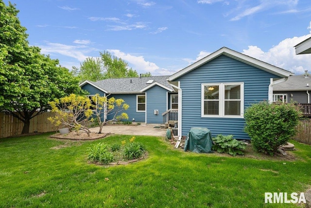 rear view of house featuring a lawn, fence, and a patio