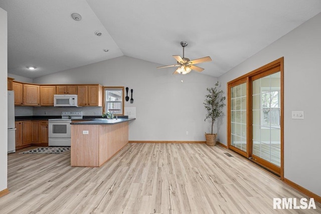 kitchen with dark countertops, vaulted ceiling, a peninsula, light wood finished floors, and white appliances