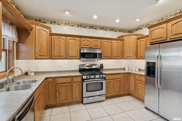 kitchen with brown cabinets, a sink, stainless steel appliances, recessed lighting, and light tile patterned floors