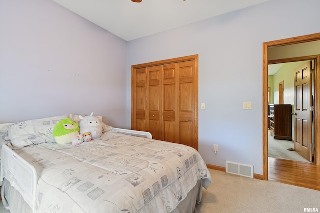 carpeted bedroom featuring visible vents, a ceiling fan, baseboards, and a closet