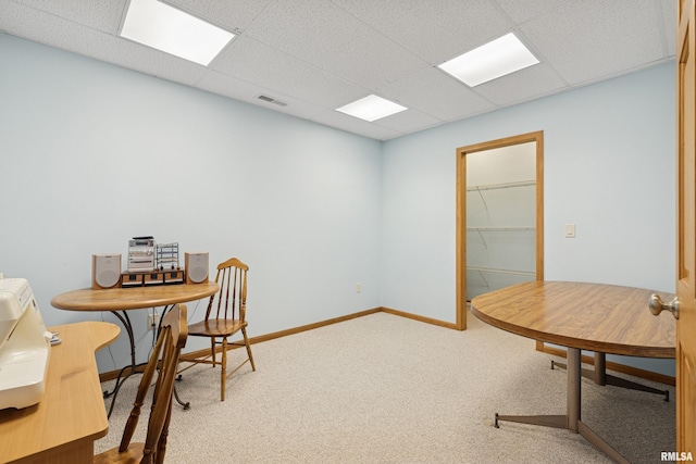 carpeted office space featuring baseboards, visible vents, and a drop ceiling