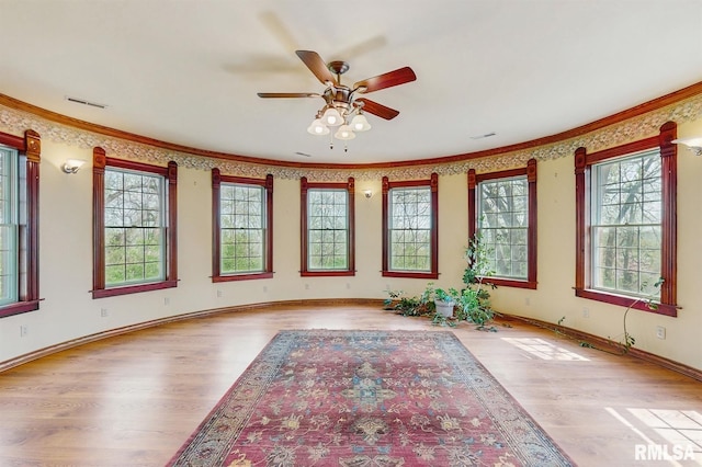 spare room with visible vents, a wealth of natural light, and wood finished floors