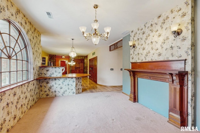kitchen featuring visible vents, carpet flooring, wallpapered walls, and a notable chandelier