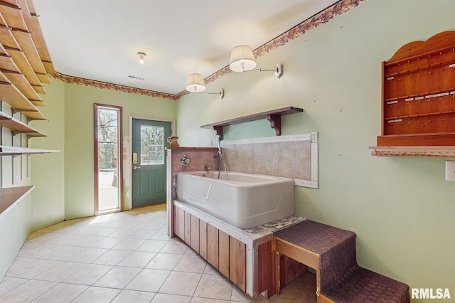 interior space featuring tile patterned flooring, a garden tub, and visible vents