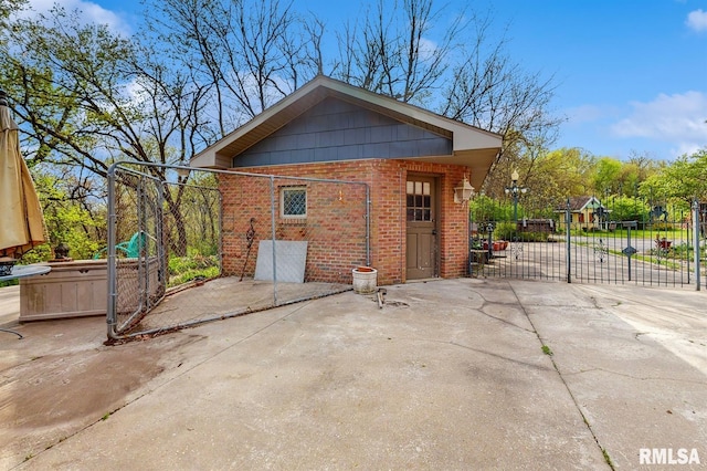 view of side of property with brick siding, a gate, and fence