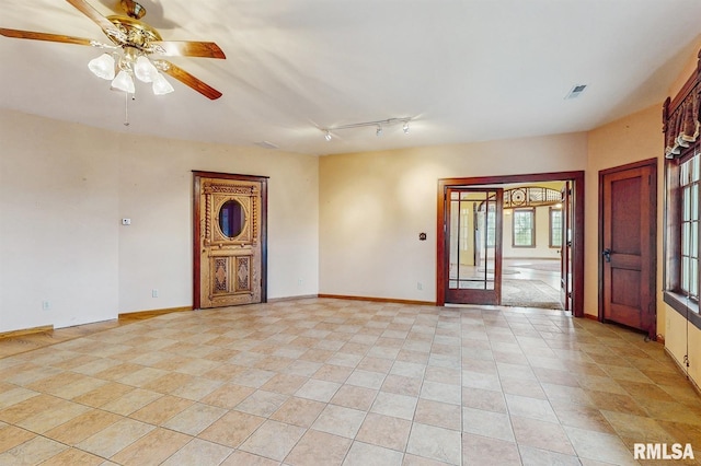 spare room featuring visible vents, baseboards, and ceiling fan