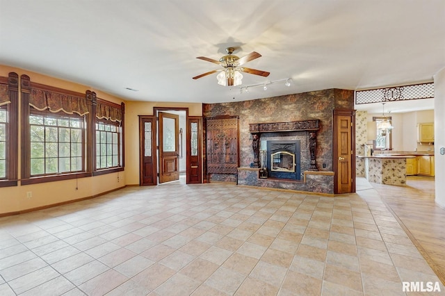 unfurnished living room featuring baseboards, a ceiling fan, rail lighting, and light tile patterned floors