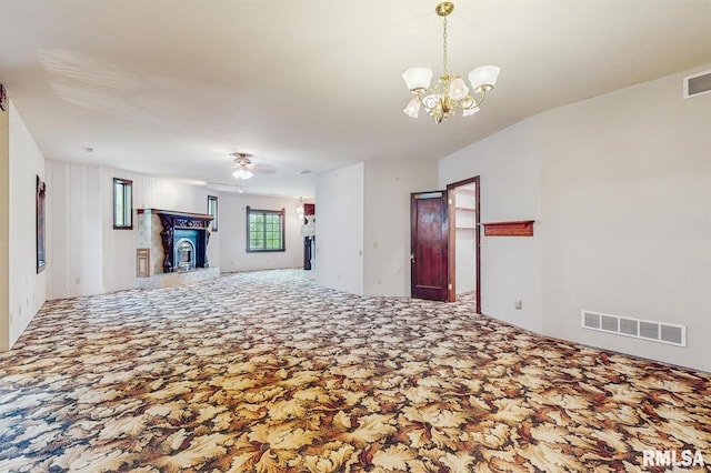 unfurnished living room featuring visible vents, ceiling fan with notable chandelier, and carpet floors