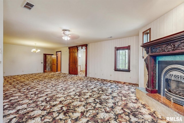 unfurnished living room featuring visible vents, a fireplace, and a notable chandelier